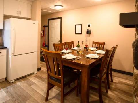 The suite's dining area features a wooden table with six chairs and a refrigerator.