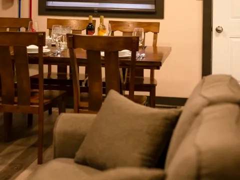 The suite offers a dining area with a wooden table adjacent to the living room.