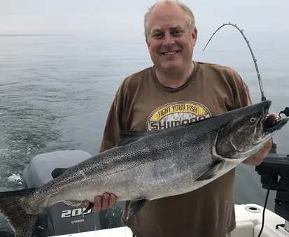 Captain Louis Bouchard with a salmon catch on Lake Ontario at Louis Pêche, Ontario