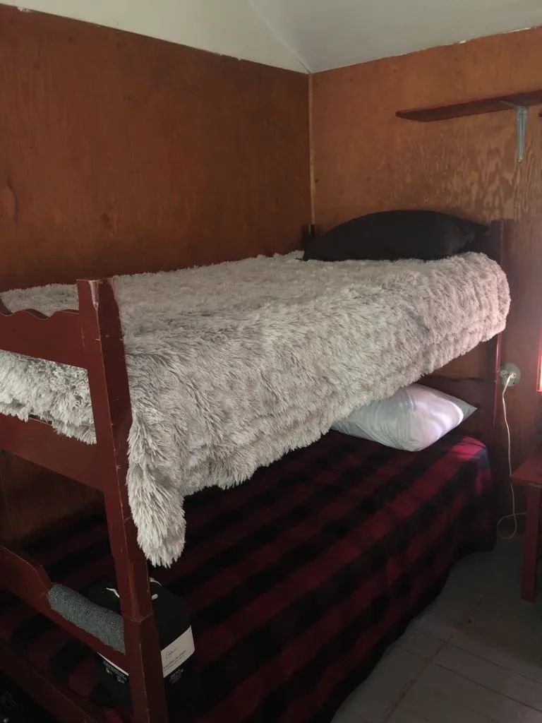 Une chambre rustique équipée de lits superposés avec literie.