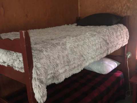 Une chambre rustique équipée de lits superposés avec literie.