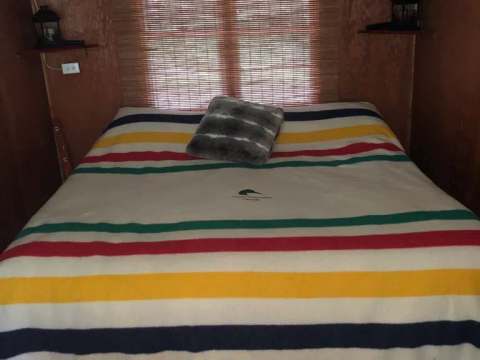 Une chambre confortable avec un lit double et des décorations rustiques au camp Serpentine.