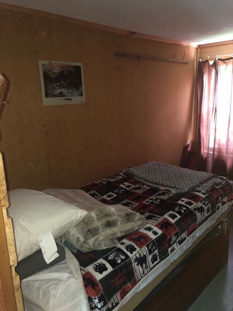 Une chambre rustique avec un lit simple au Serpentine Camp.