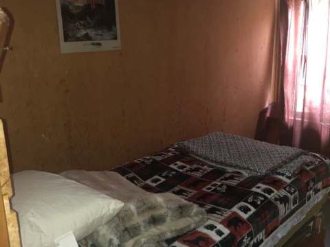 Une chambre rustique avec un lit simple au Serpentine Camp.