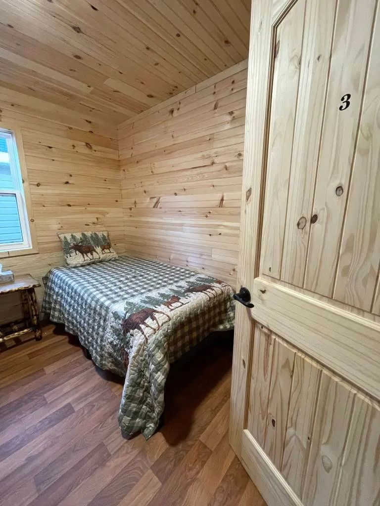 This private bedroom features a single bed and rustic wood decor.