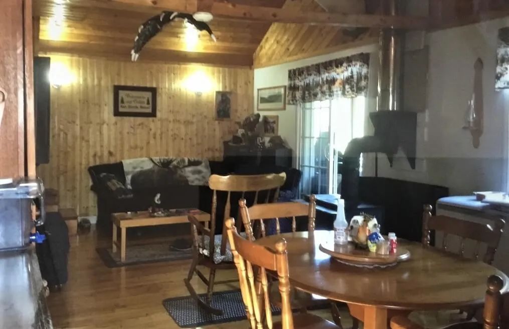 The cottage's dining and living area offers a comfortable relaxation space with a wood stove.