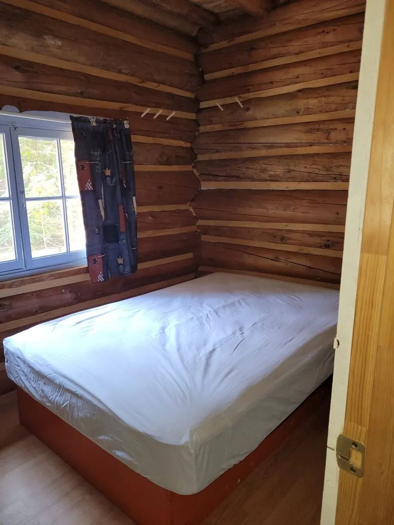 Vue d'une chambre à coucher avec lit double dans le camp Claire-Fontaine.