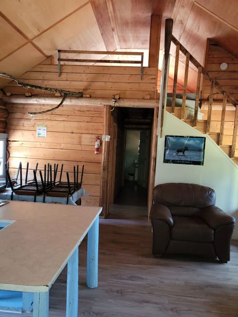 Vue intérieure de la aire ouverte du Camp Claire-Fontaine avec son salon et son escalier.