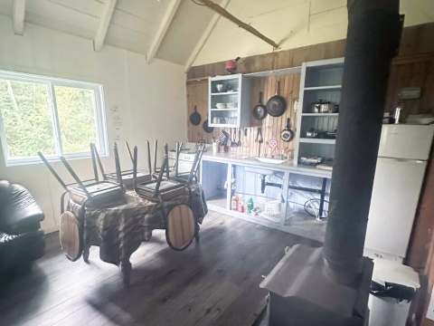 La cuisine fonctionnelle du camp Farfadet comprend une table à manger et un poêle à bois.