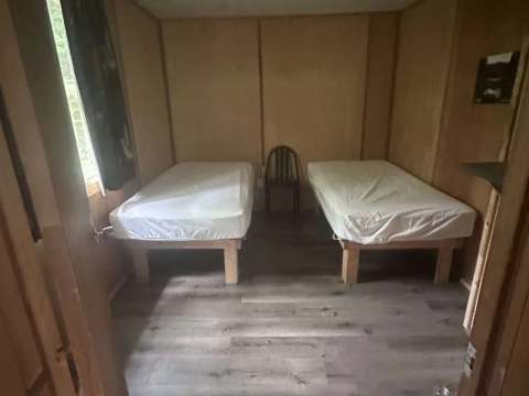 Cette chambre rustique du camp Farfadet est équipée de deux lits simples.