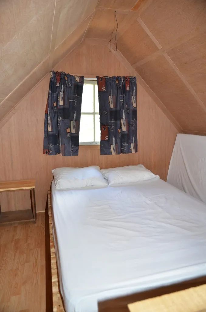 Vue de la chambre sous le toit avec un lit double dans le camp Refuge.