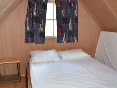 Vue de la chambre sous le toit avec un lit double dans le camp Refuge.