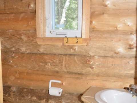 Vue de la salle de bain en bois rond du Camp Refuge.