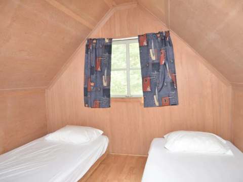 Cette chambre sous le toit du camp Refuge est aménagée avec deux lits simples.