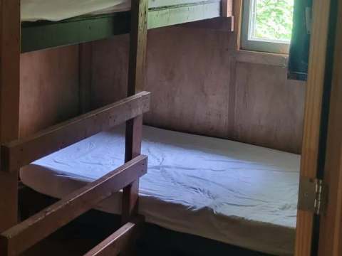 Cette chambre du camp Villa-Dama comprend un lit superposé avec literie simple.