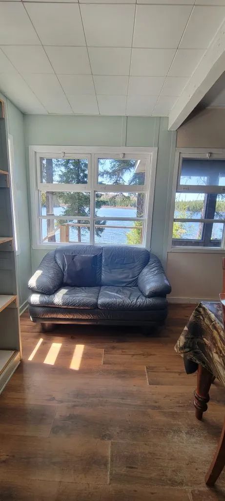 The cottage living room offers a relaxing space with a view of the lake.
