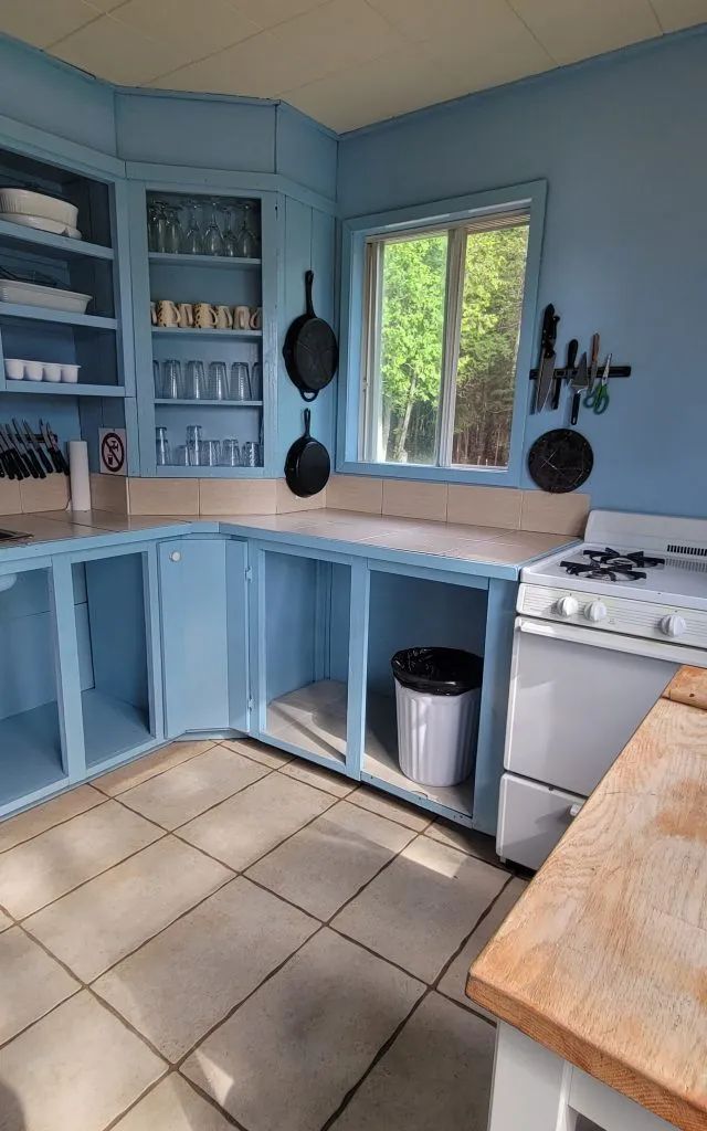 The kitchen in Chalet Des Pins features open storage, a stove, and cooking utensils.