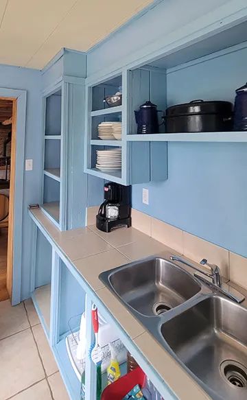 The cottage's functional kitchen features a double sink and open storage shelves.