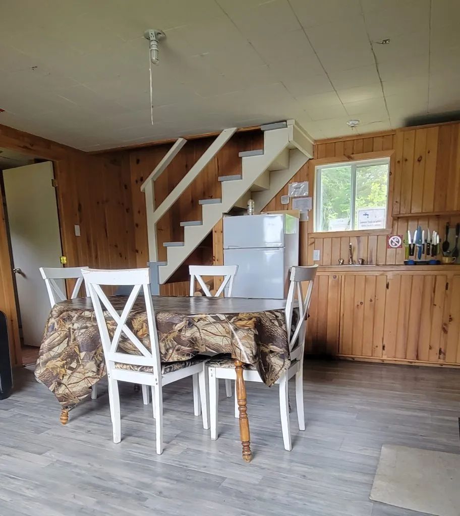 The cottage dining area features a table with chairs and access to the kitchen spaces.