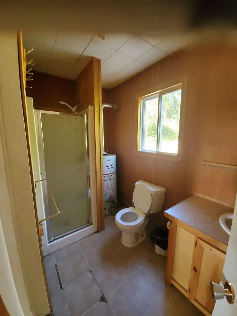 La salle de bain fonctionnelle du chalet inclut une douche, une toilette et un lavabo.