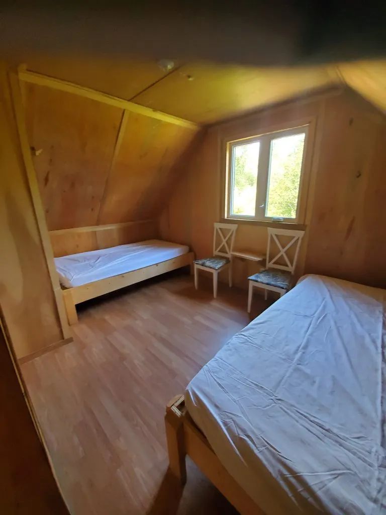 Cette chambre sous le toit du chalet Gobelin dispose de deux lits simples et d'une fenêtre.