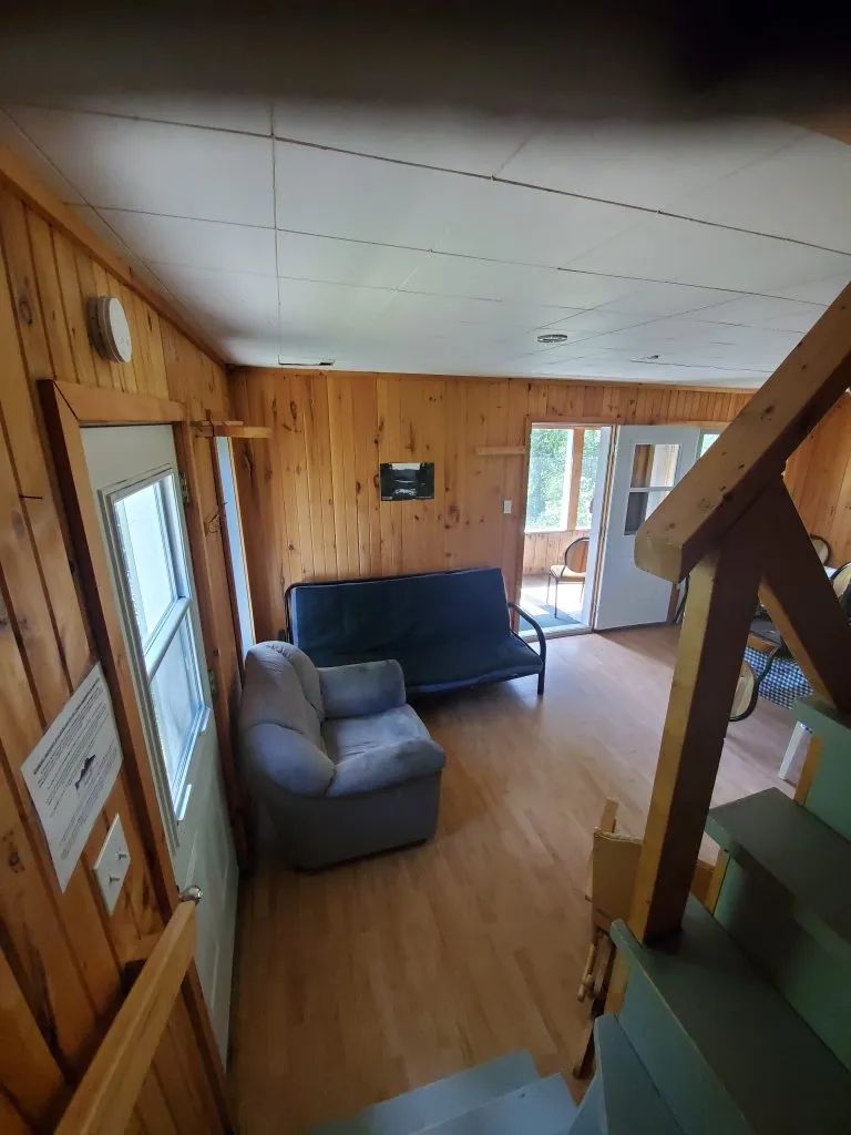 Le salon du chalet Gobelin comprend des sièges et donne accès à une galerie extérieure.