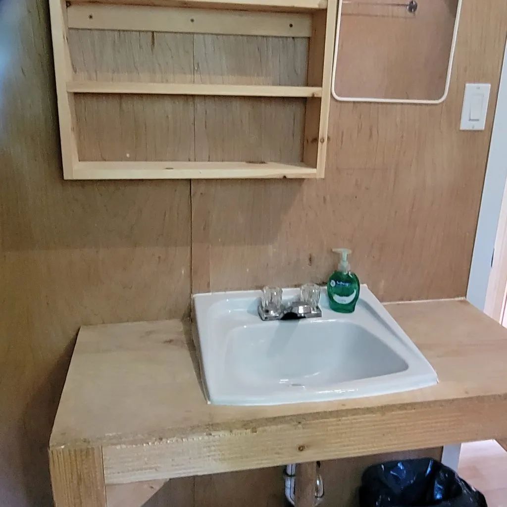 Le lavabo installé sur un comptoir en bois dans la salle de bain du chalet.