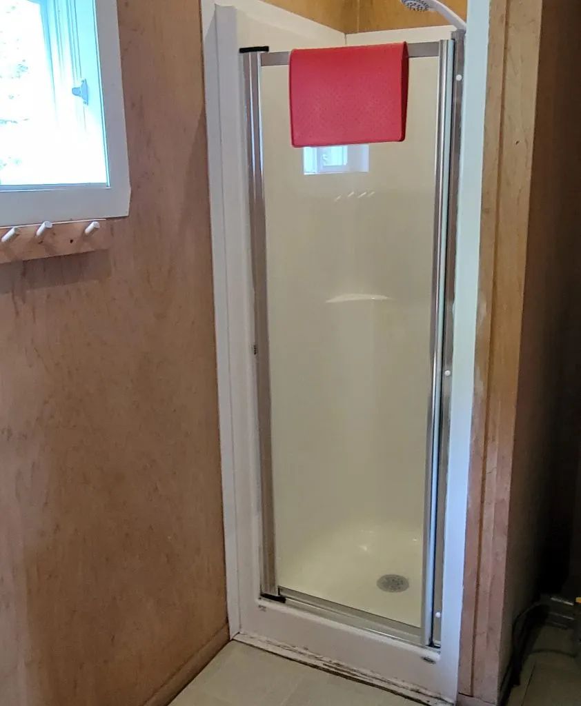 La salle de bain du chalet Huard comprend une douche avec porte vitrée.