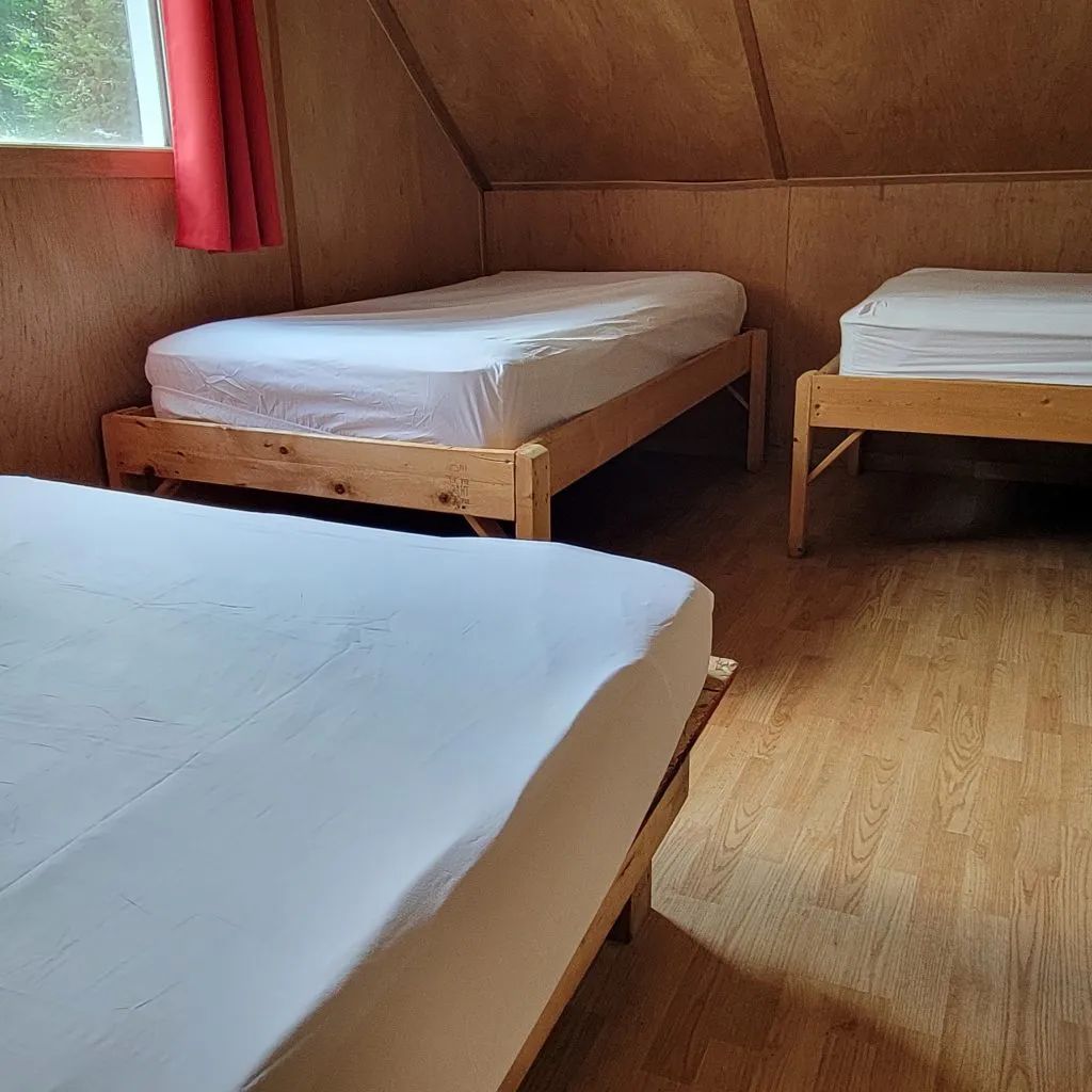 Chambre avec plusieurs lits dans le chalet Huard.