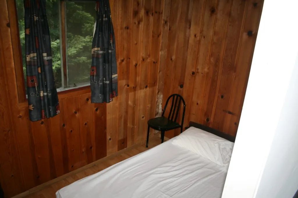 Une chambre rustique avec un lit simple dans le chalet Jenny.