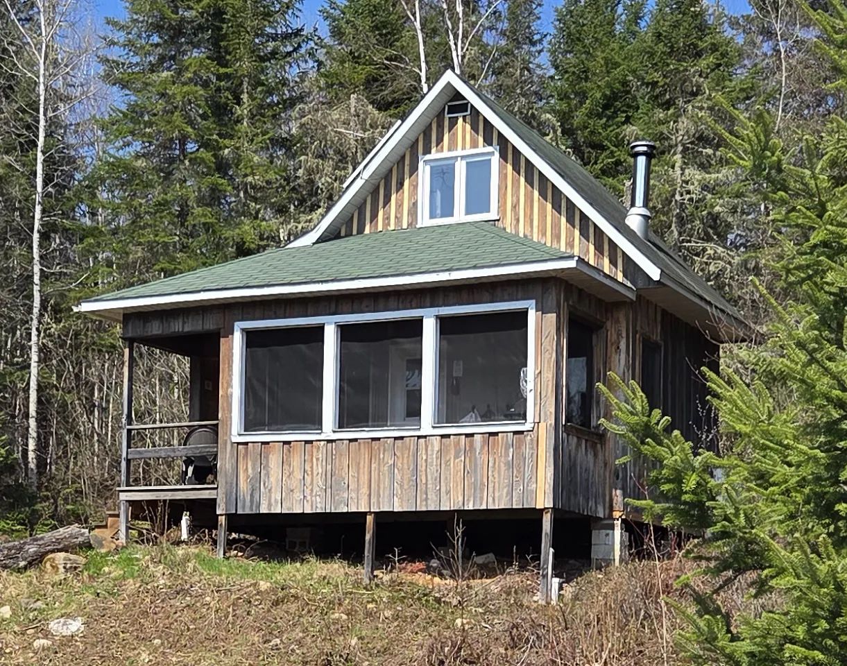 Le chalet Perchaude dispose d'une galerie couverte et d'un revêtement en bois rustique.