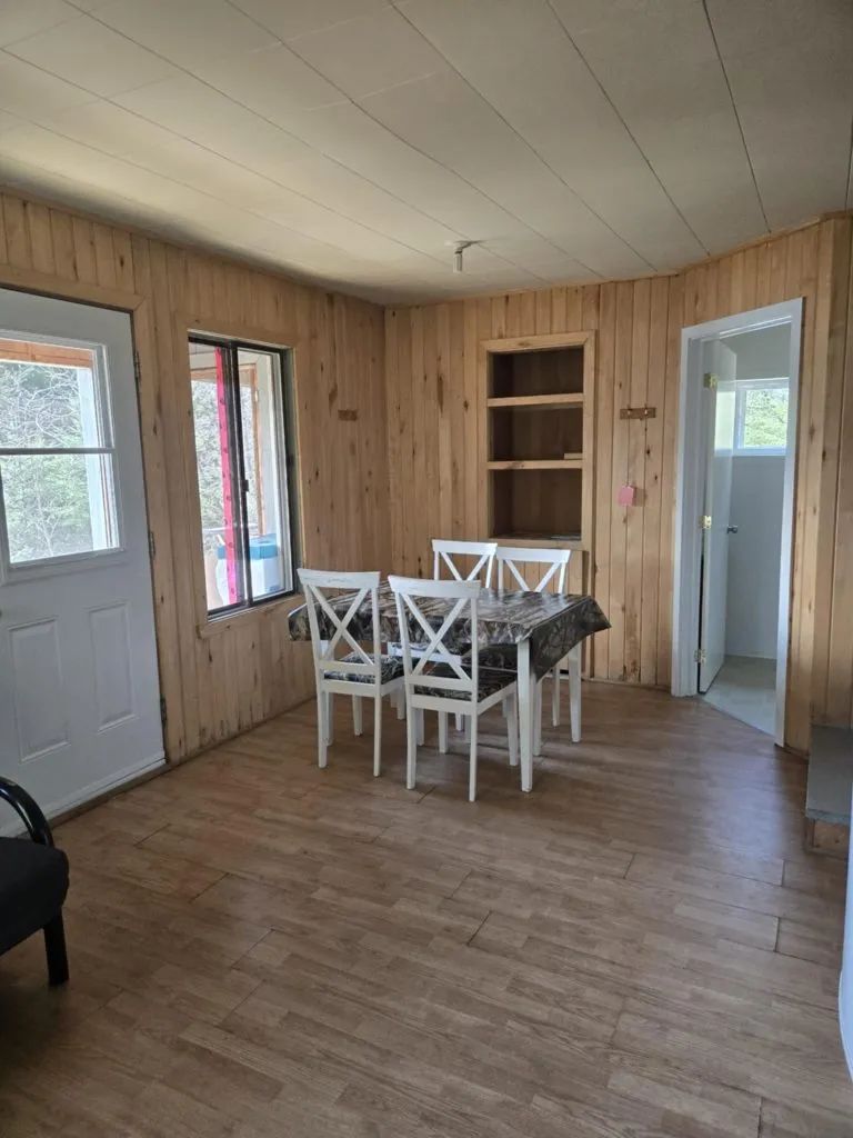 La salle à manger du chalet dispose d'une table avec quatre chaises en bois.