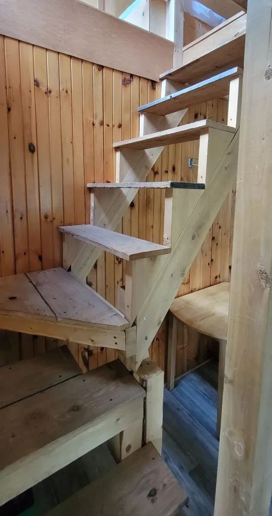 A wooden staircase leads to the upper floor of the cabin.