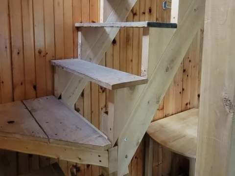 A wooden staircase leads to the upper floor of the cabin.