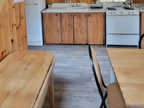 The chalet's functional kitchen is equipped with a stove, a refrigerator, and a table.
