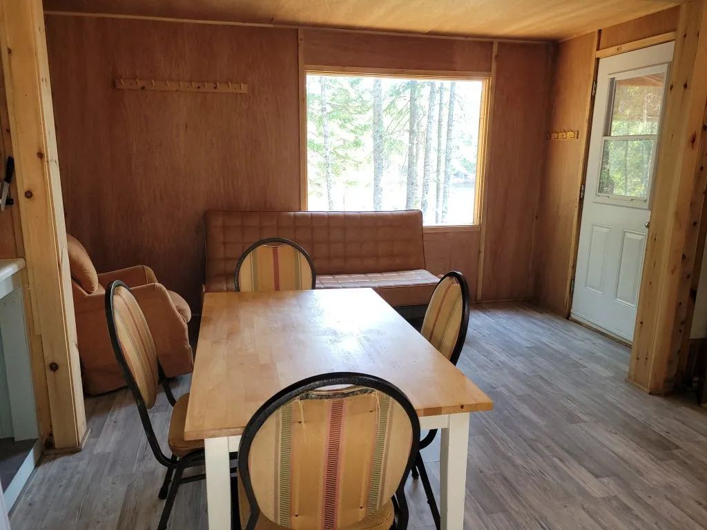 The dining area and living space of the Troll cabin offer a view of the surrounding forest.