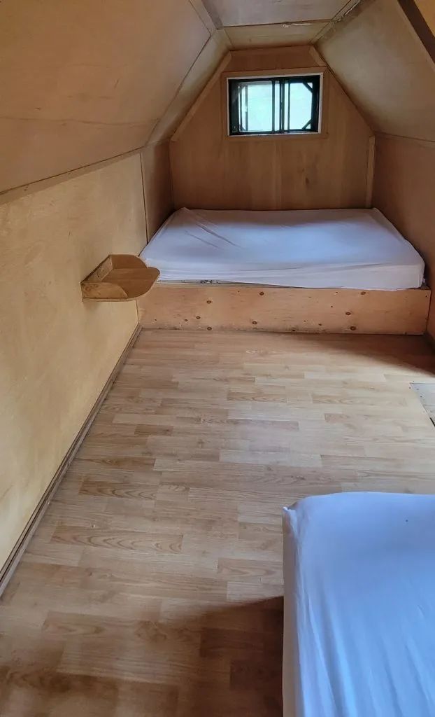 The bedroom under the eaves of the Troll cabin provides a sleeping area with two beds.
