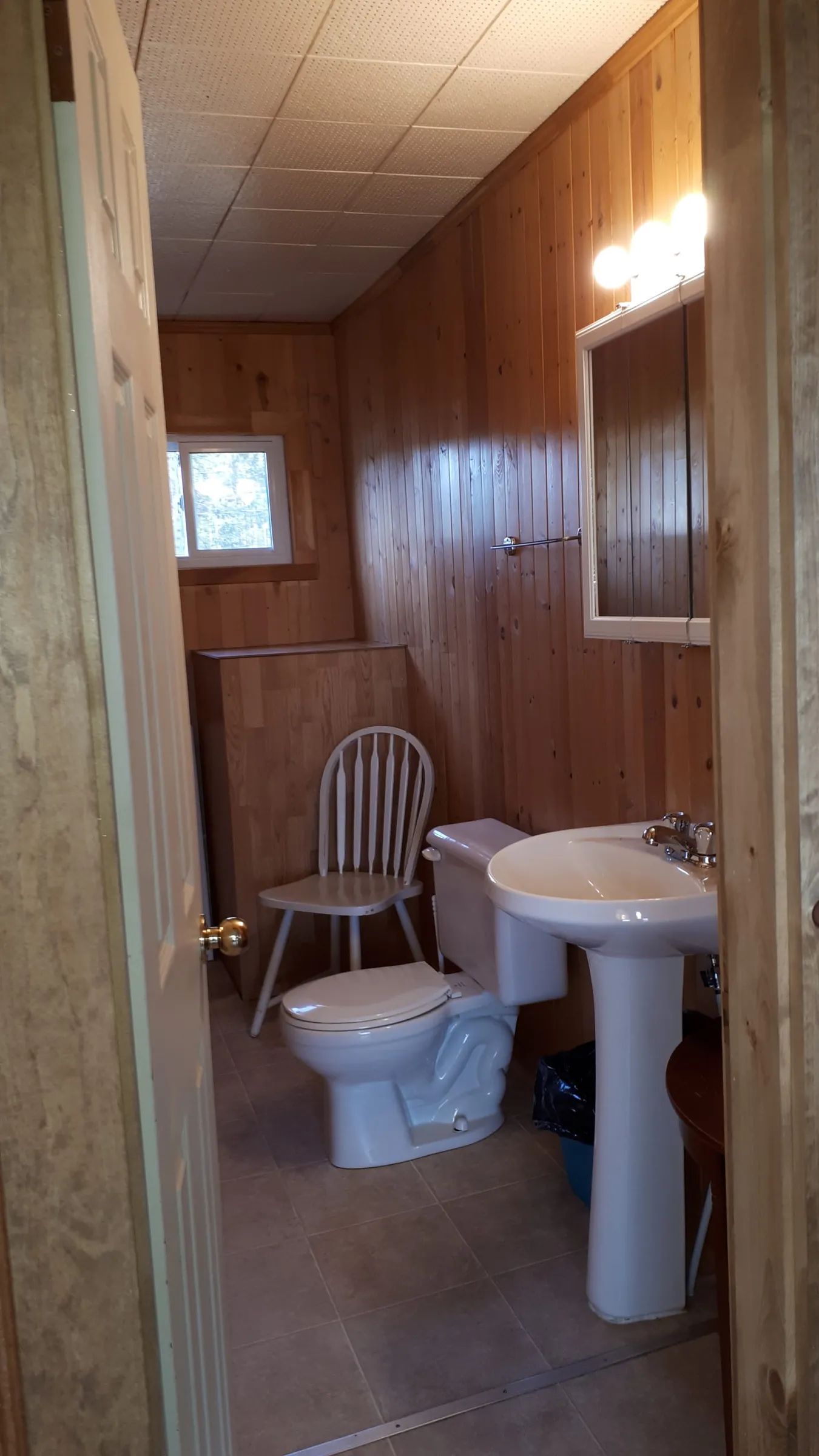 The cottage bathroom features a pedestal sink and a toilet.