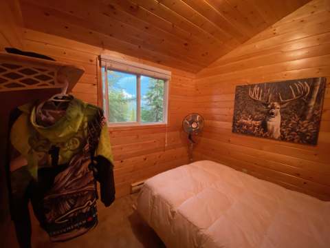 This comfortable bedroom features a cozy bed and rustic wood decor.