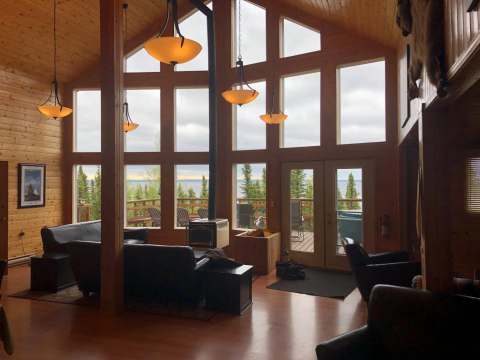 The main lodge's common area offers an unobstructed view of the lake and surrounding forest.