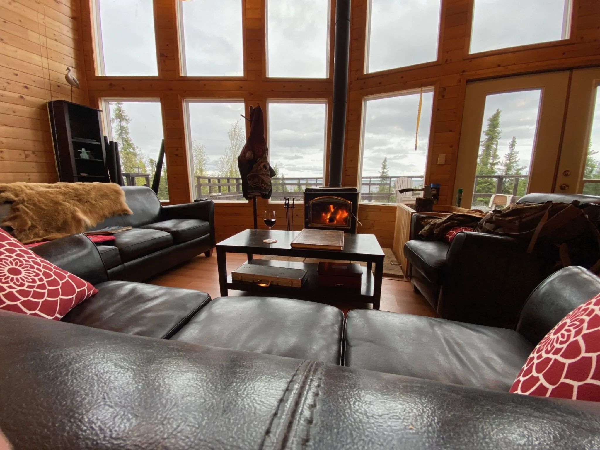 A comfortable living room with a wood stove, offering a panoramic view of the surrounding nature.