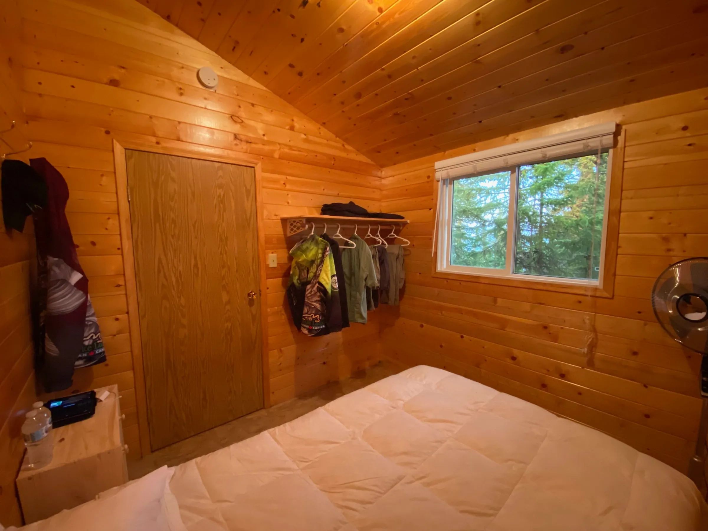 A comfortable bedroom with bed and wall storage in the main lodge.