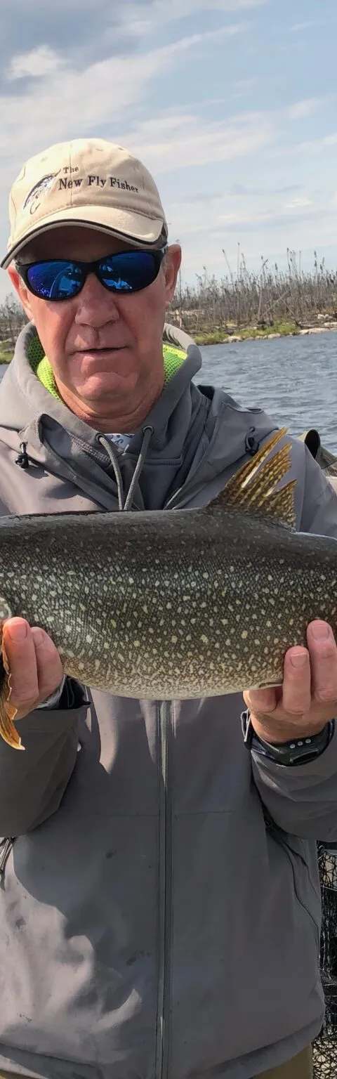 Angler presenting his lake trout catch at Milton Lake Lodge, Athabasca Basin, Saskatchewan